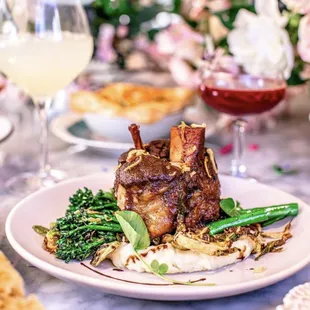 Join us for dinner! Our Pork Shank is cooked in red wine reduction and served with grilled broccolini, brussel sprout, and mashed potatoes.
