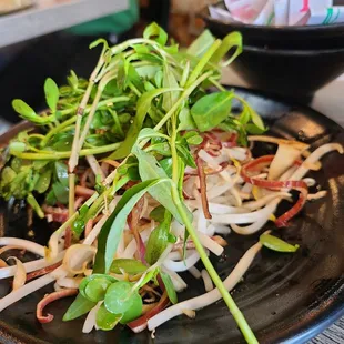 a black plate with a salad on it
