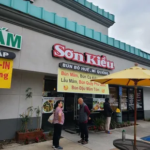 people standing outside of a restaurant
