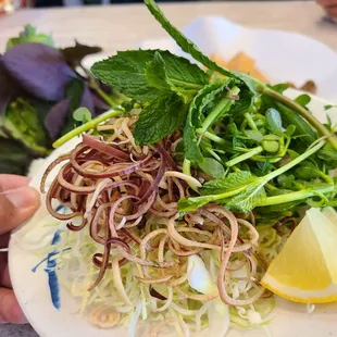 a plate of food with noodles and greens