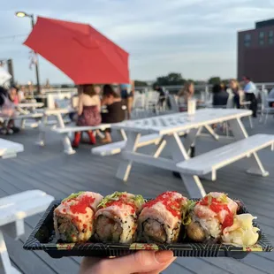 a person holding a plate of sushi