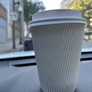 a coffee cup sitting on the dashboard of a car