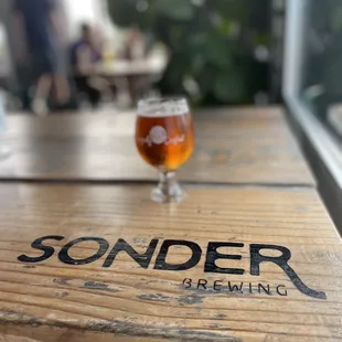 a glass of beer on a wooden table