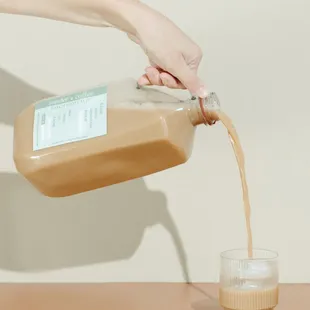 a person pouring coffee into a glass