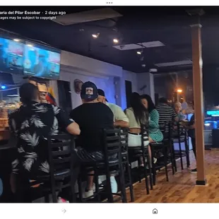 a group of people sitting at a bar