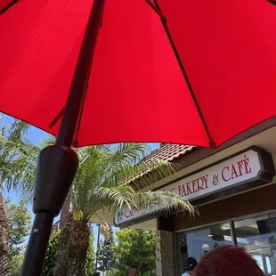 Store sign from under an umbrella on the front patio
