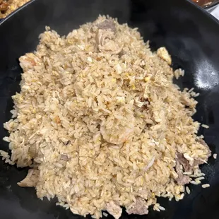 a plate of fried rice with meat and vegetables