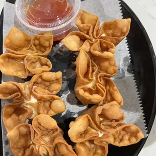 a plate of wontons with dipping sauce