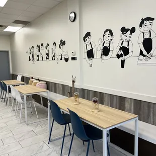 a long table with chairs and a clock on the wall