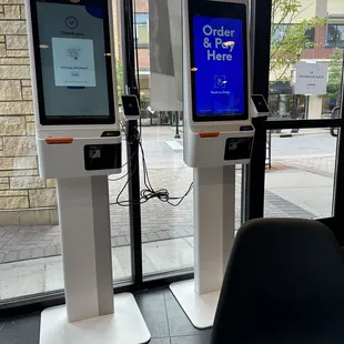 two digital kiosks in front of a window