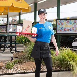 a woman holding a pizza box