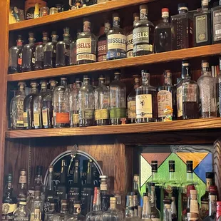 a shelf full of liquor bottles