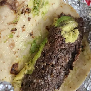 Barabacoa taco on flour plain with avocado