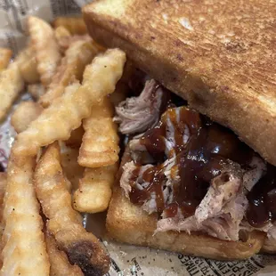 Lunch serving of bbq chicken on garlic bread with fries