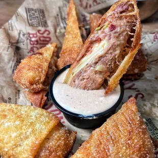 a close up of a sandwich with dipping sauce