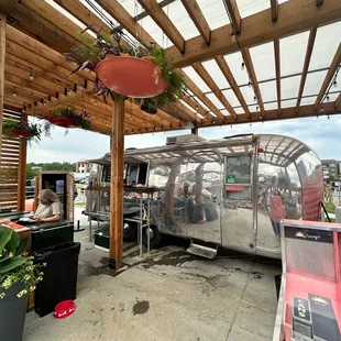 a vintage airstream parked under a pergol roof