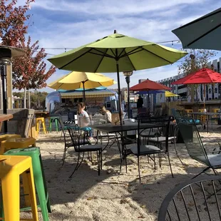 tables and chairs with umbrellas