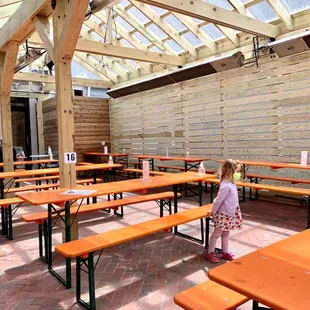 a little girl standing in the middle of a patio