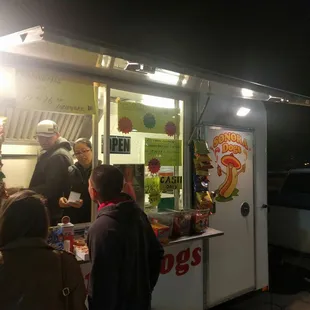 a group of people standing outside of a food truck