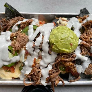 a plate of pulled pork nachos