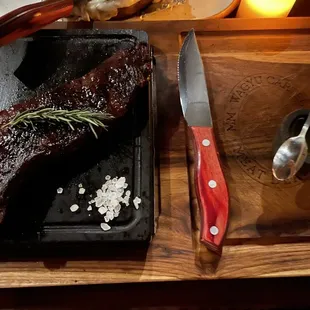 a steak on a cutting board with a knife