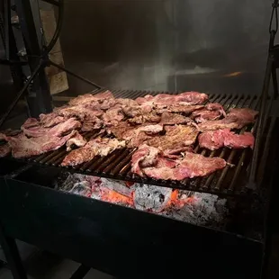 steaks cooking on a grill