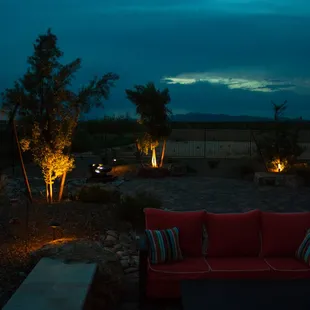a red couch in a backyard at night