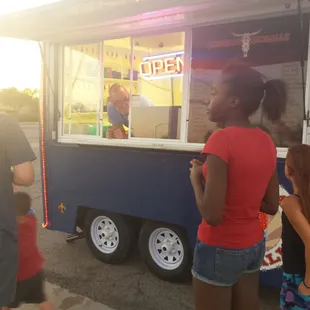 a woman ordering food from a food truck
