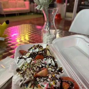 an ice cream sundae with sprinkles and strawberries