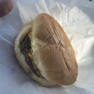 a hand holding a hamburger