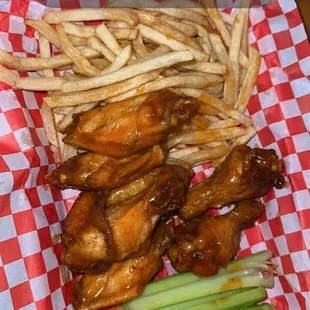 a basket of chicken wings and french fries