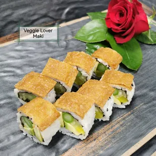 a plate of sushi rolls and a rose