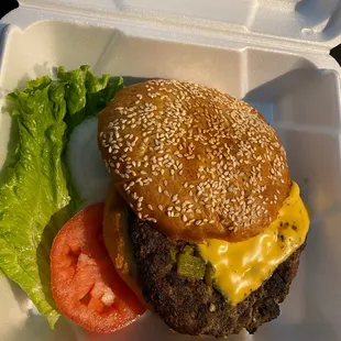 a cheeseburger with lettuce and tomato