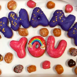 a box of doughnuts with the word joy written in the middle