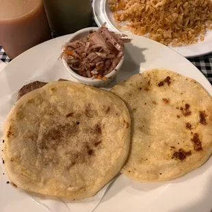 Two pupusas with a side of rice. Pupusas are delicious, the loroco is great, and accompanying salsas add to it.