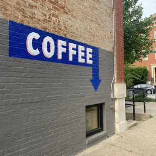 a blue arrow on a brick building