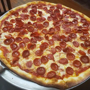 a pepperoni pizza on a pizza pan