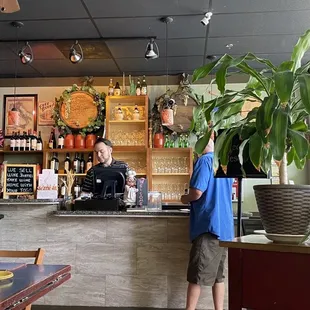 a man standing at the counter of a restaurant