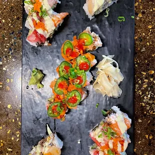 a variety of sushi on a black plate