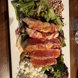 Seared tuna, wrapped in thin prosciutto on a beet salad accompanied by goat cheese, greens, roasted pistachios and walnuts. Amazingly good!