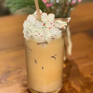 a cup of iced coffee with whipped cream and sprinkles