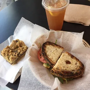 Bacon, egg and cheddar with veggies on country white, berry oat bar, and an iced tea.