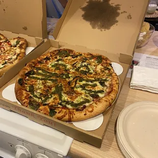 two pizzas in open boxes