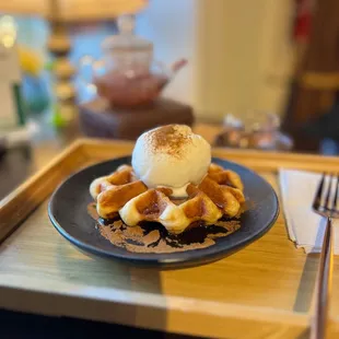 Croissant and Waffle -- waffle made of croissant bread topped with vanilla ice cream, cinnamon and maple syrup