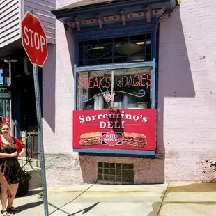 a woman standing next to a stop sign