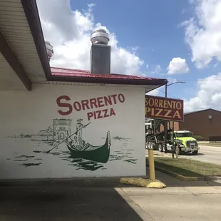 Mural of Venezia on the outside wall by the drive in Window.
