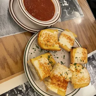 a plate of grilled cheese sandwiches and a bowl of tomato soup