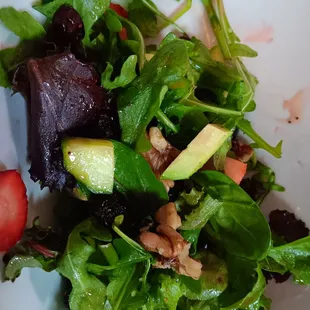 a closeup of a salad with strawberries and avocado