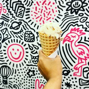 a hand holding an ice cream cone