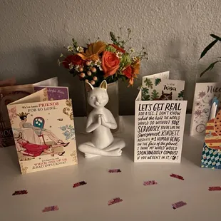 a vase of flowers and cards on a table